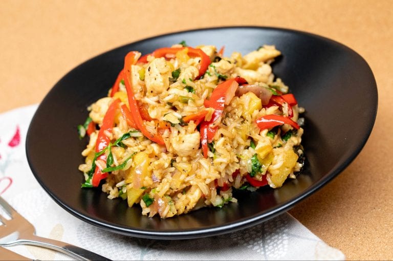 Rys en hoenderslaai bedien in 'n bak, geklee met vars groente.