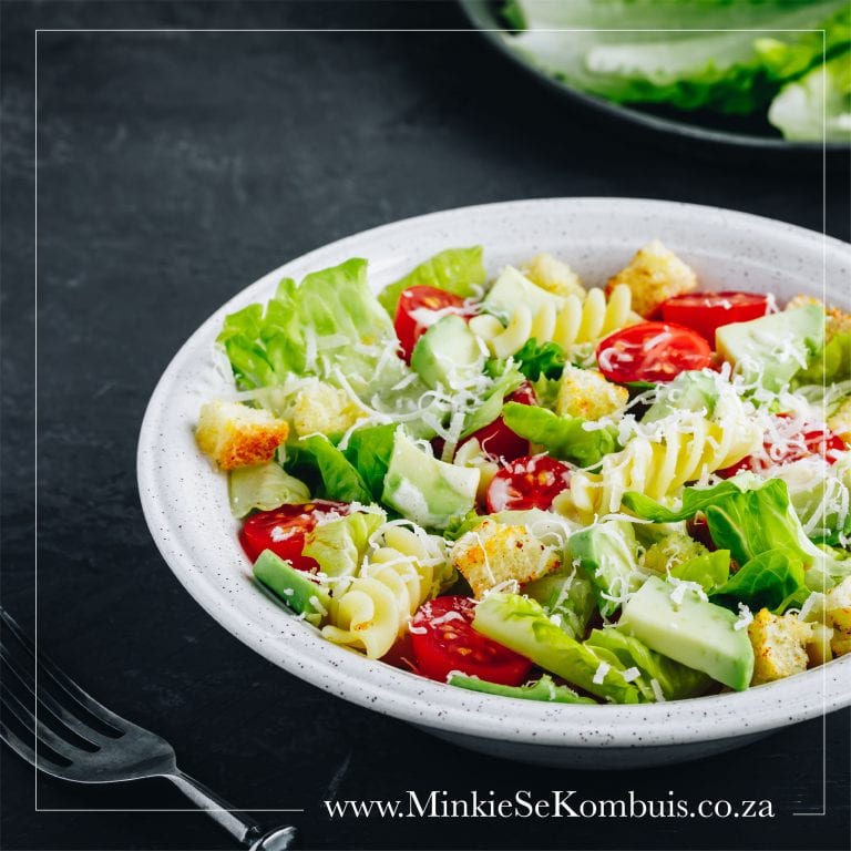 A colorful pasta salad with mixed vegetables, olives, and a light dressing, served in a bowl.