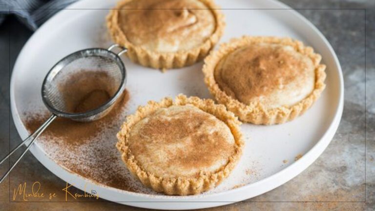 Tradisionele Suid-Afrikaanse melktert met 'n bros, goudbruin kors en romerige vanielje-vulsel, gestrooi met kaneel.